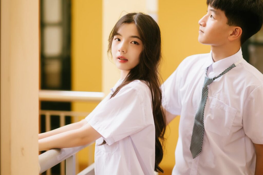 Teenage couple in Lạng Sơn, Vietnam, standing on a balcony in school uniforms.